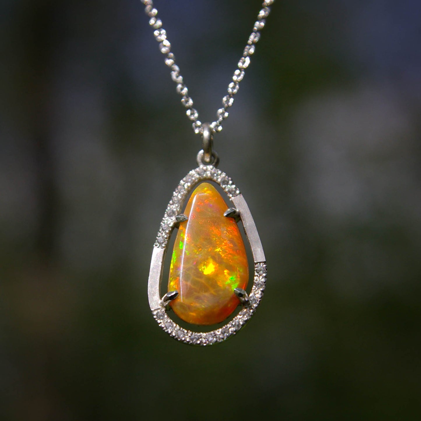 Ce pendentif en argent 925 met en valeur la beauté flamboyante d'une opale de feu. Parfait pour les femmes qui aiment affirmer leur style audacieux et moderne.