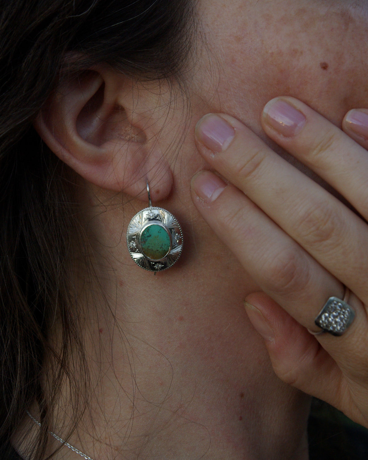 Détai porté des quatre étoiles gravées à la main sur une boucle d’oreille artisanale en argent 925