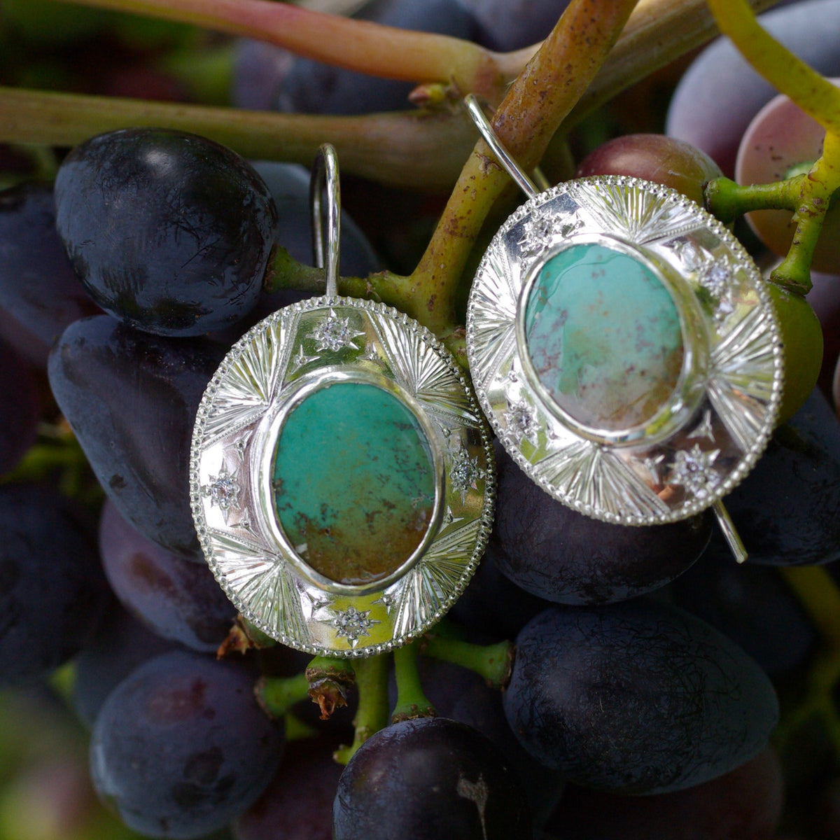 Turquoises vertes naturelles mouchetées aux motifs uniques serties au centre de boucles d’oreilles en argent