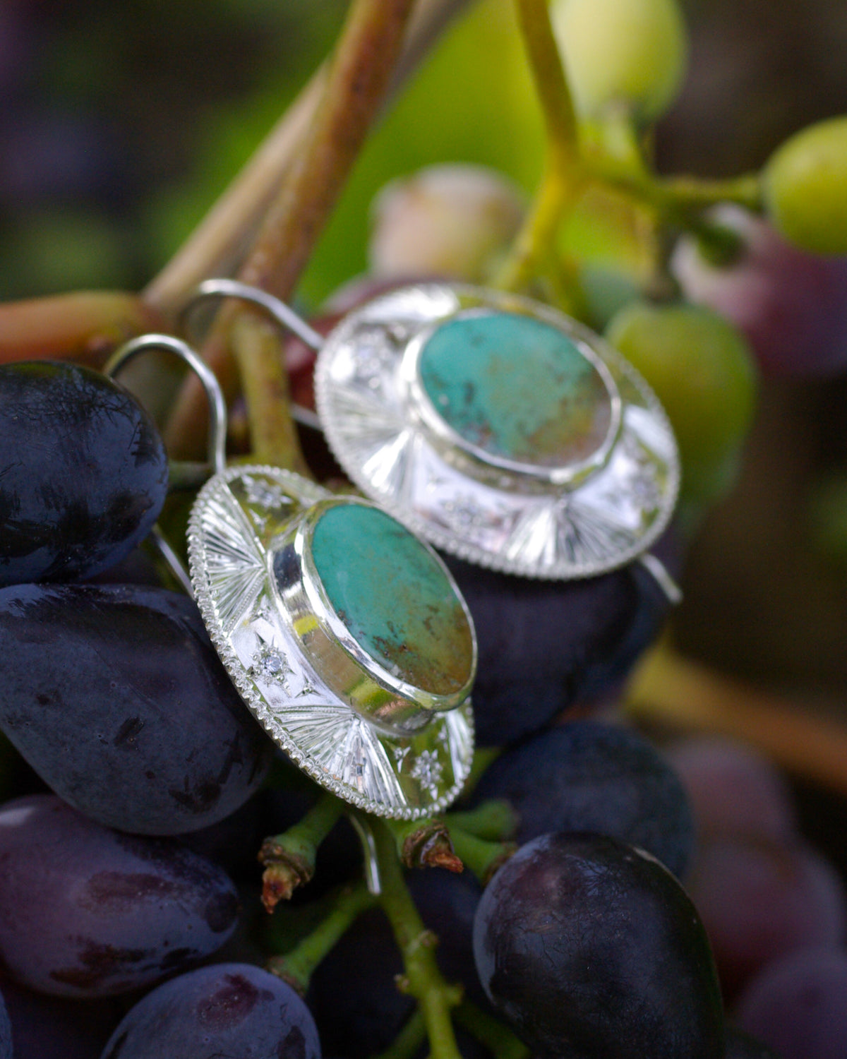 Détail d’une boucle d’oreille en argent poli avec turquoise verte naturelle et quatre étoiles gravées à la main