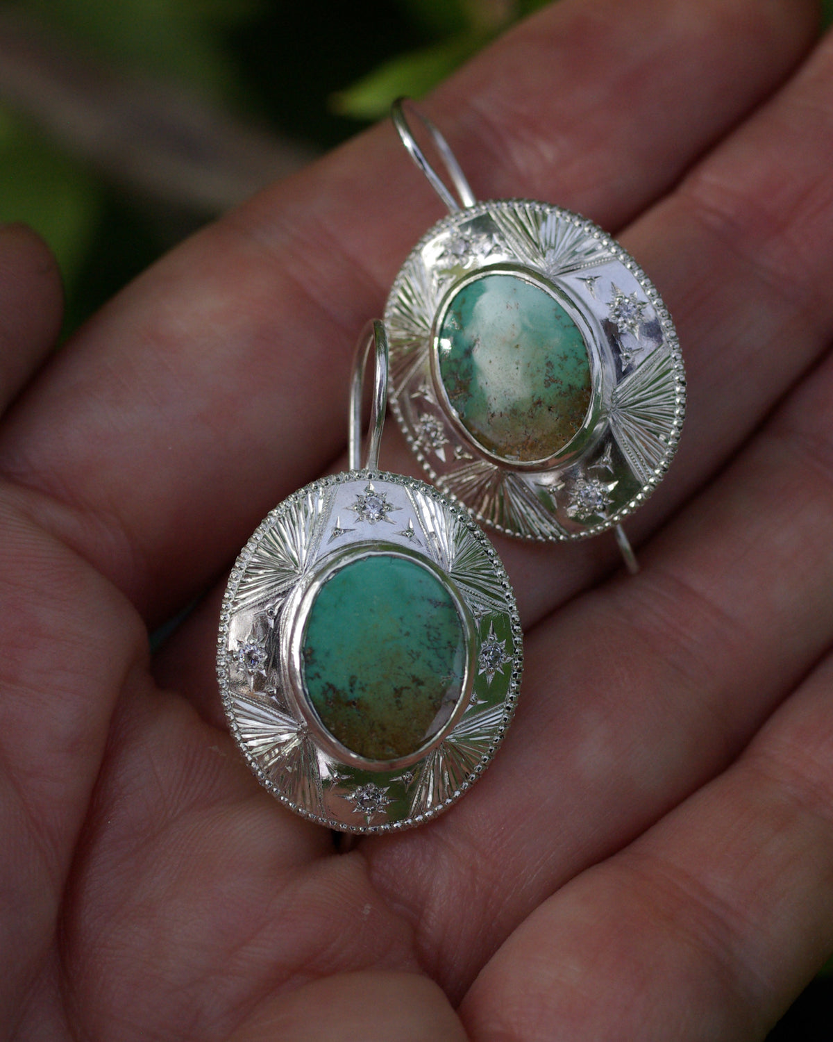 Détail de l’argent poli et de la turquoise verte naturelle mouchetée sur une boucle d’oreille artisanale