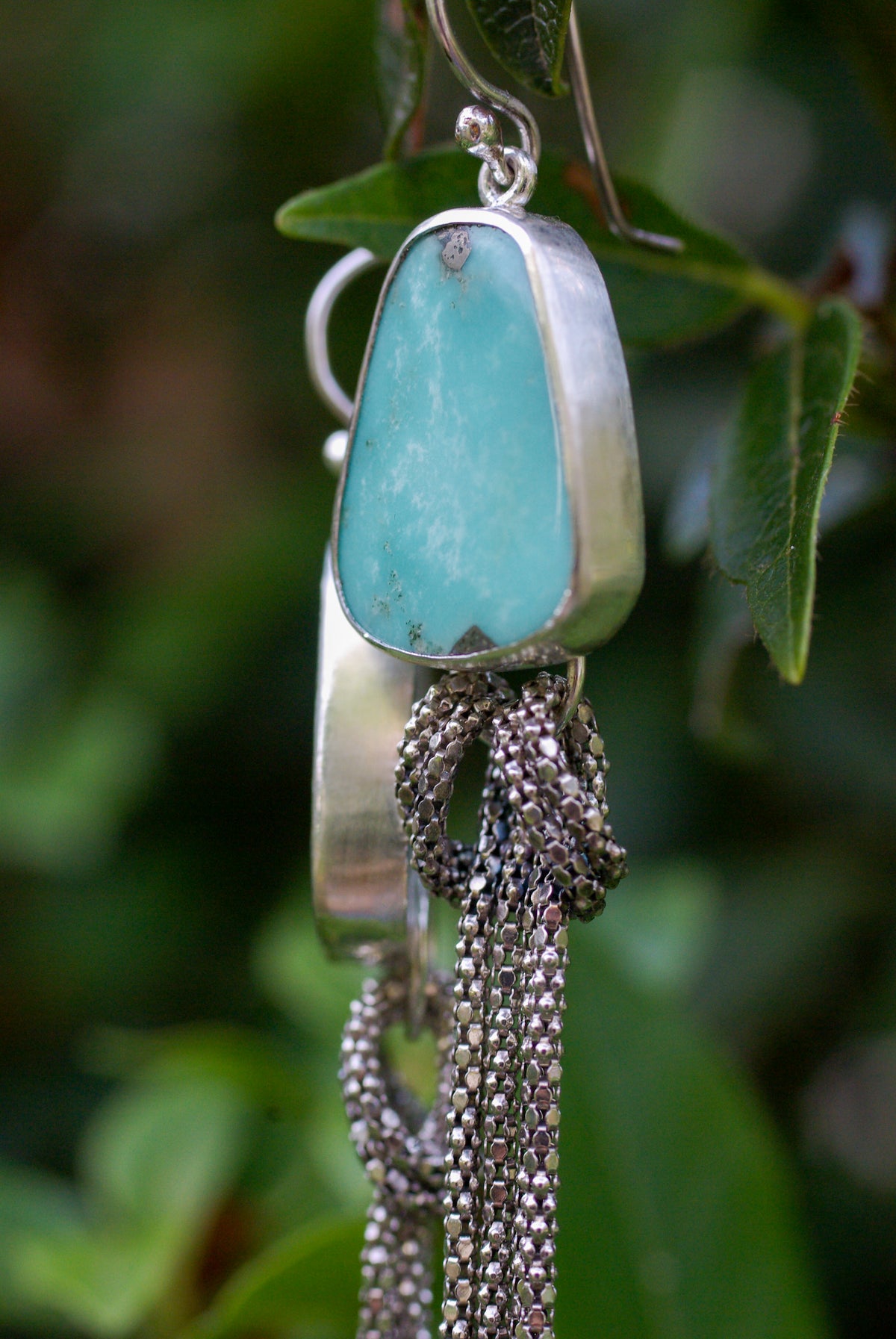 Détail d’une turquoise naturelle d’Arizona bleu clair sur une boucle d’oreille artisanale en argent 925