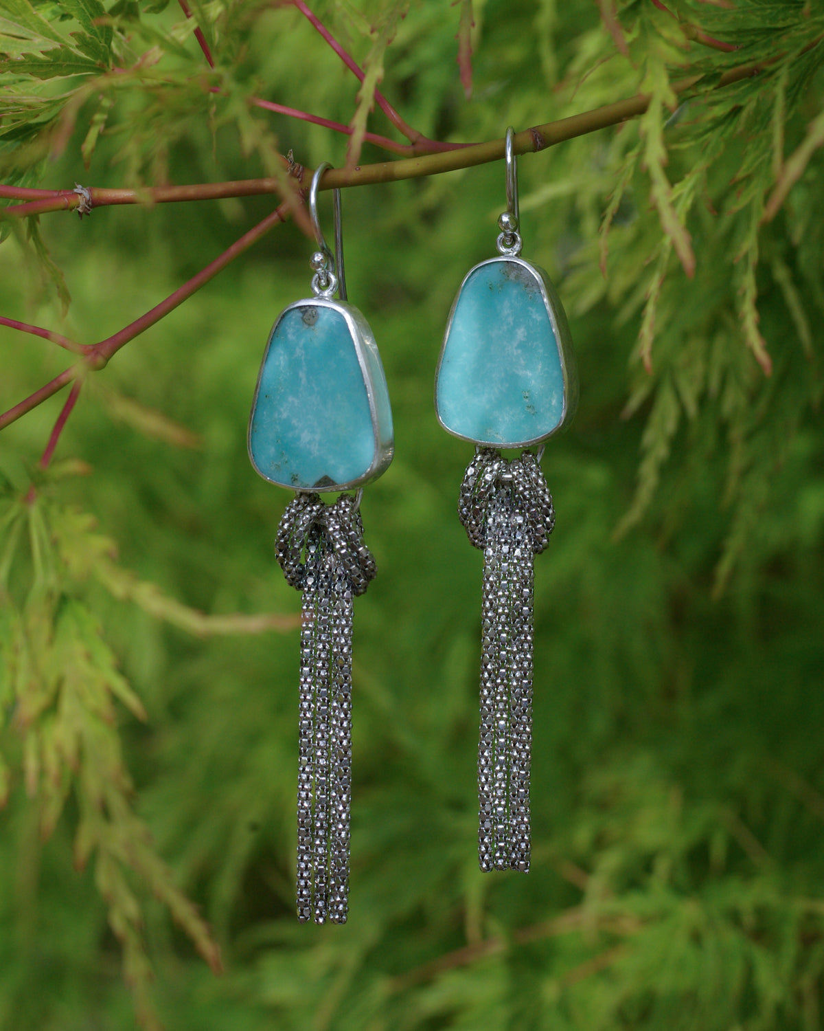 Détail des fines chaînettes en argent formant un noeud sous une turquoise d’Arizona naturelle