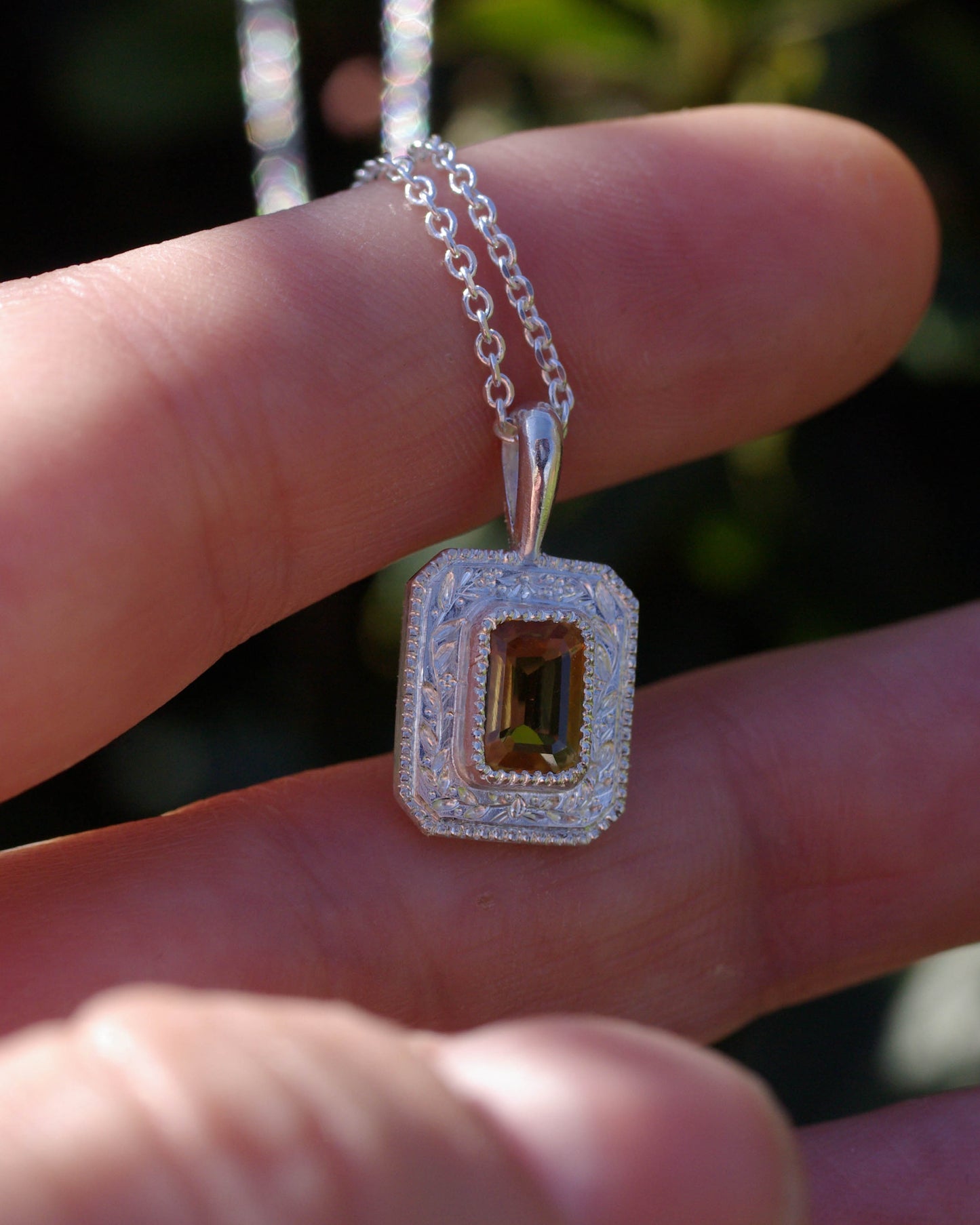 Petit pendentif en argent gravé et citrine vue main