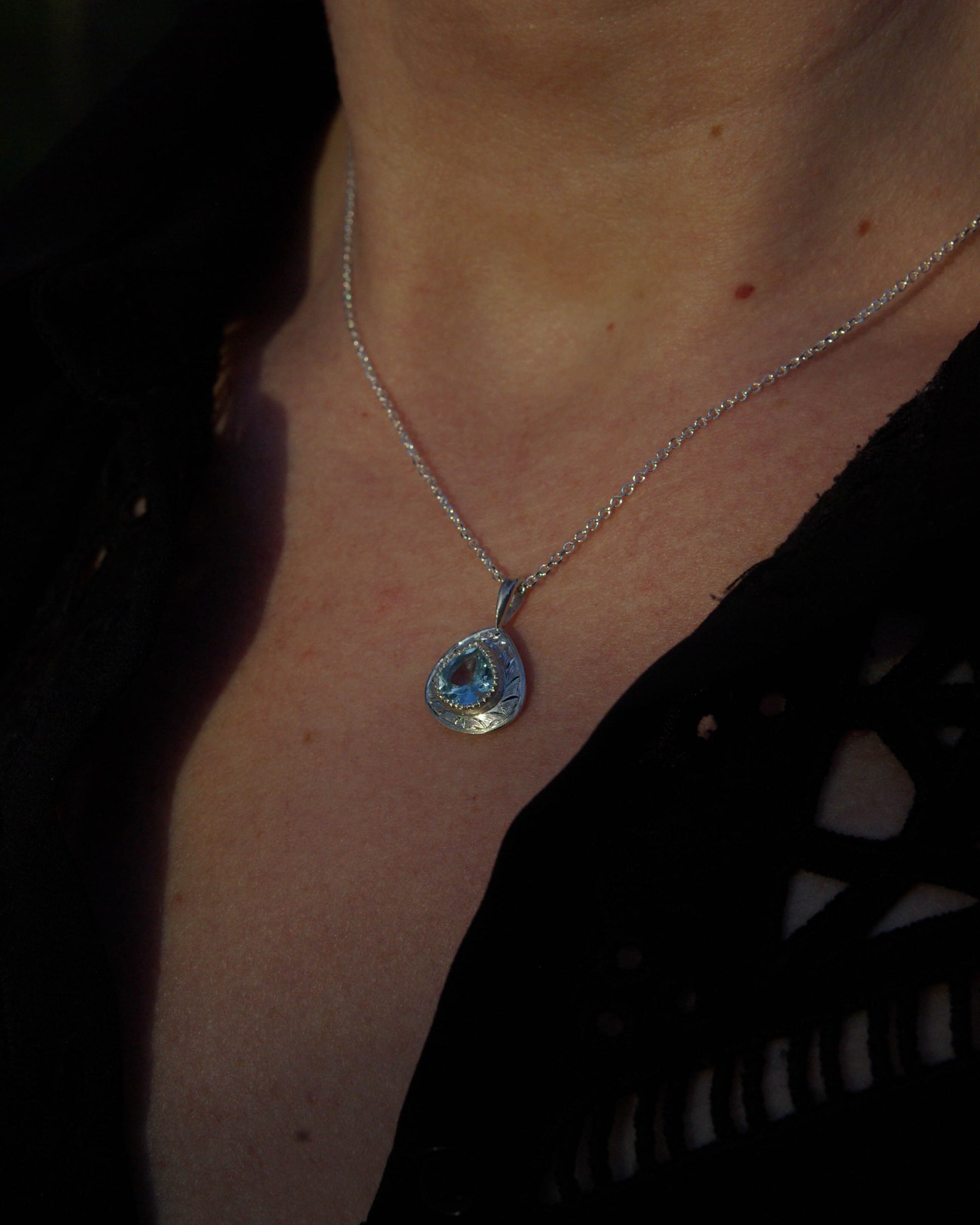 Pendentif en argent 925 gravé style romantique et topaze bleue porté
