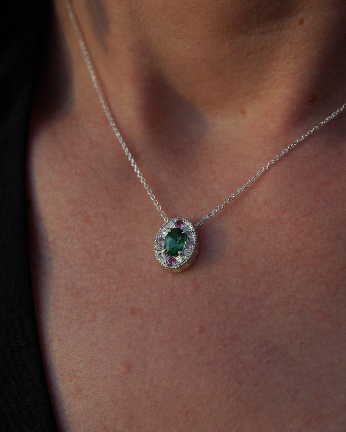 Détail porté d'un pendentif en argent gravé à la main avec tourmaline verte naturelle du Congo et pierres roses