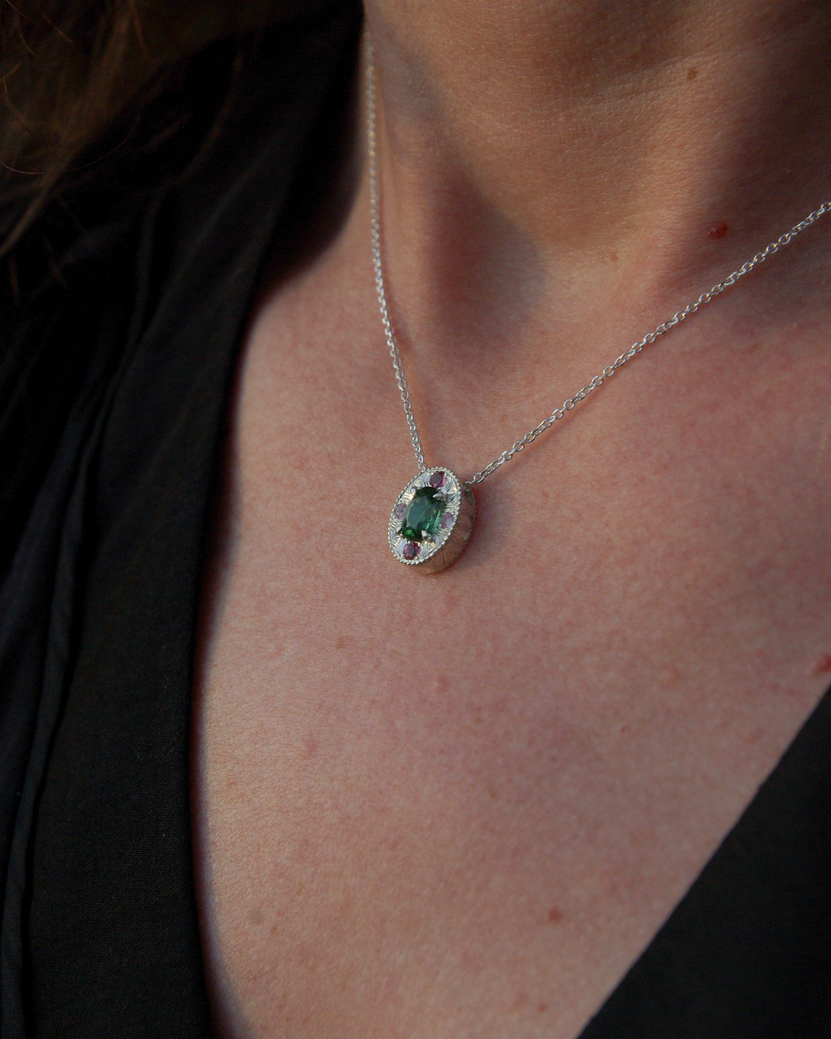 Vue porté profil d'un pendentif en argent gravé à la main avec tourmaline verte naturelle du Congo et pierres roses