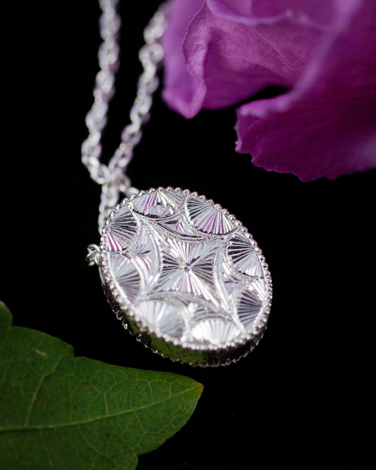 Détail de la gravure réalisée à la main sur le dos d’un pendentif artisanal en argent