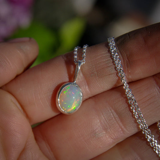 Ce pendentif en argent 925 délicat présente une opale blanche douce et scintillante. Un bijou idéal pour un style simple et minimaliste.